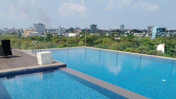 Une piscine rectangulaire à l’eau d’un bleu limpide, entourée d’une terrasse carrelée.
