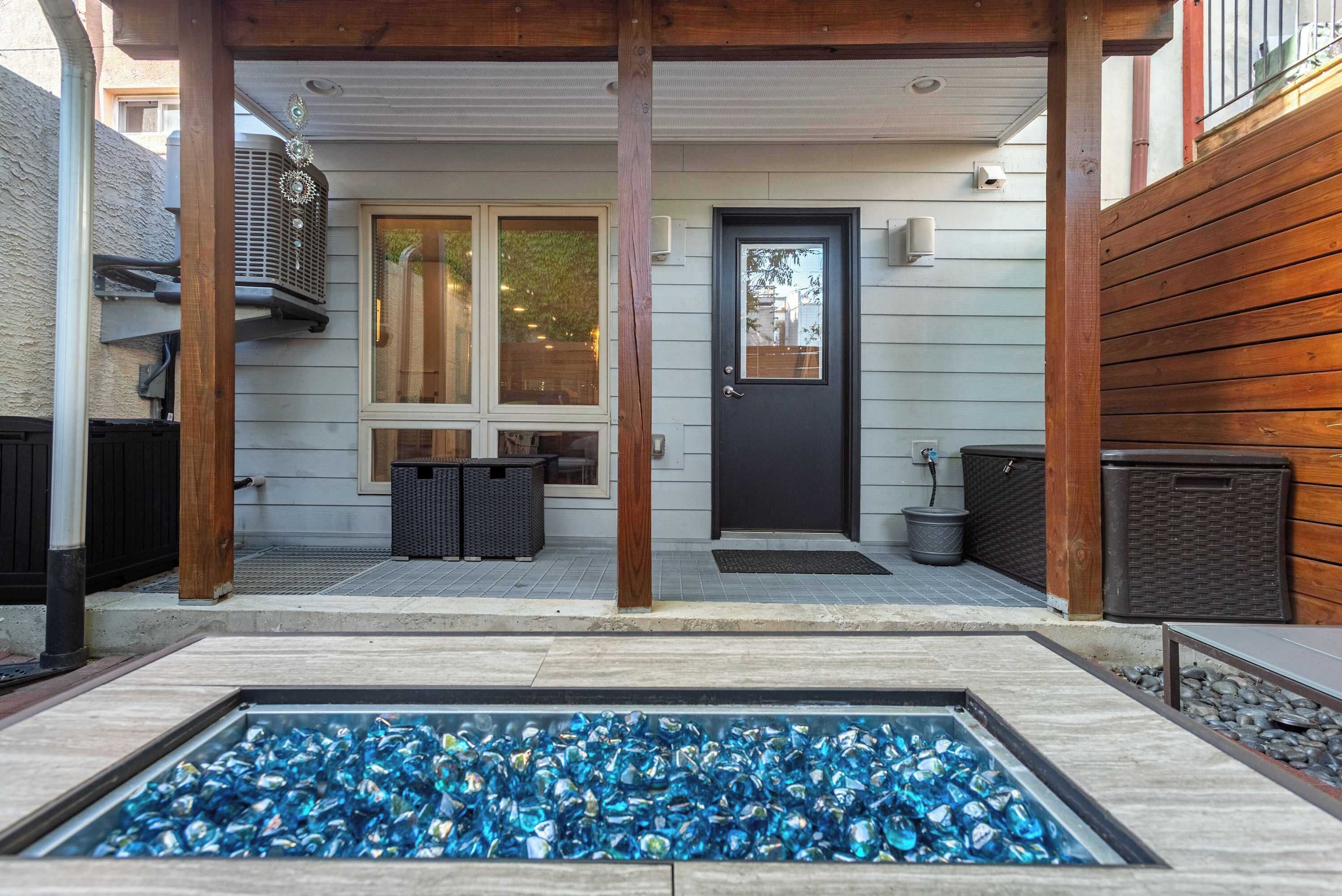 A covered patio with a swimming pool, a door, and a window.