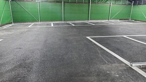 An indoor sports court with green walls and a dark floor, marked with white lines. - Gimhae H. Avenue (Gimhae)