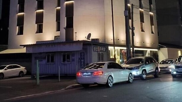 A hotel with a prominent 'HI' sign, multiple windows, and a 'GRAND OPEN' banner. - Gimhae H. Avenue (Gimhae)