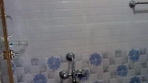 Ein Badezimmer mit Dusche, gefliesten Wänden und einem blauen Boden.