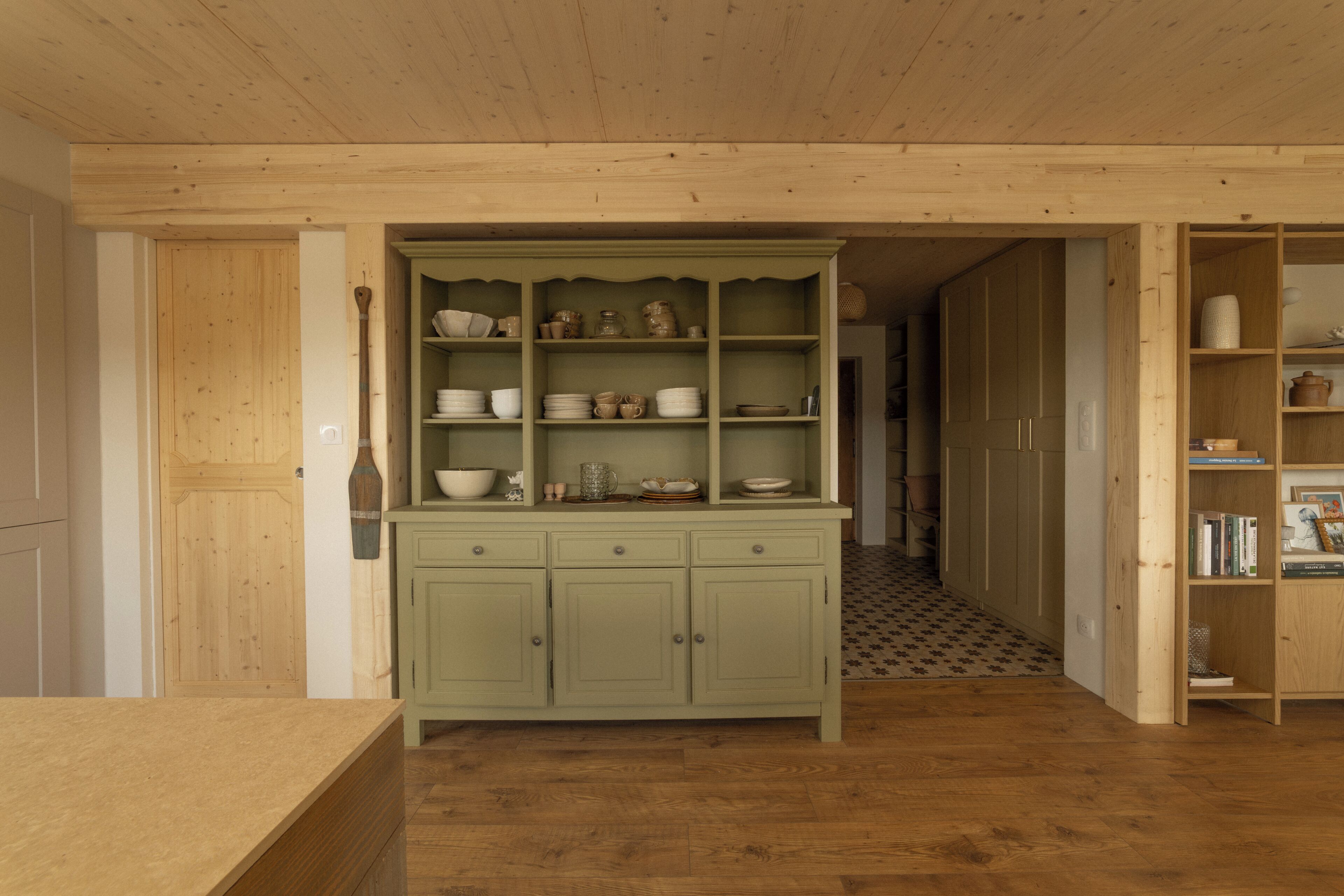 A kitchen with wooden cabinets, a countertop, and a patterned floor.