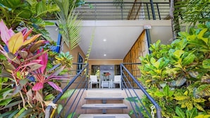 A staircase with metal railings leading to a room with a table and chairs.