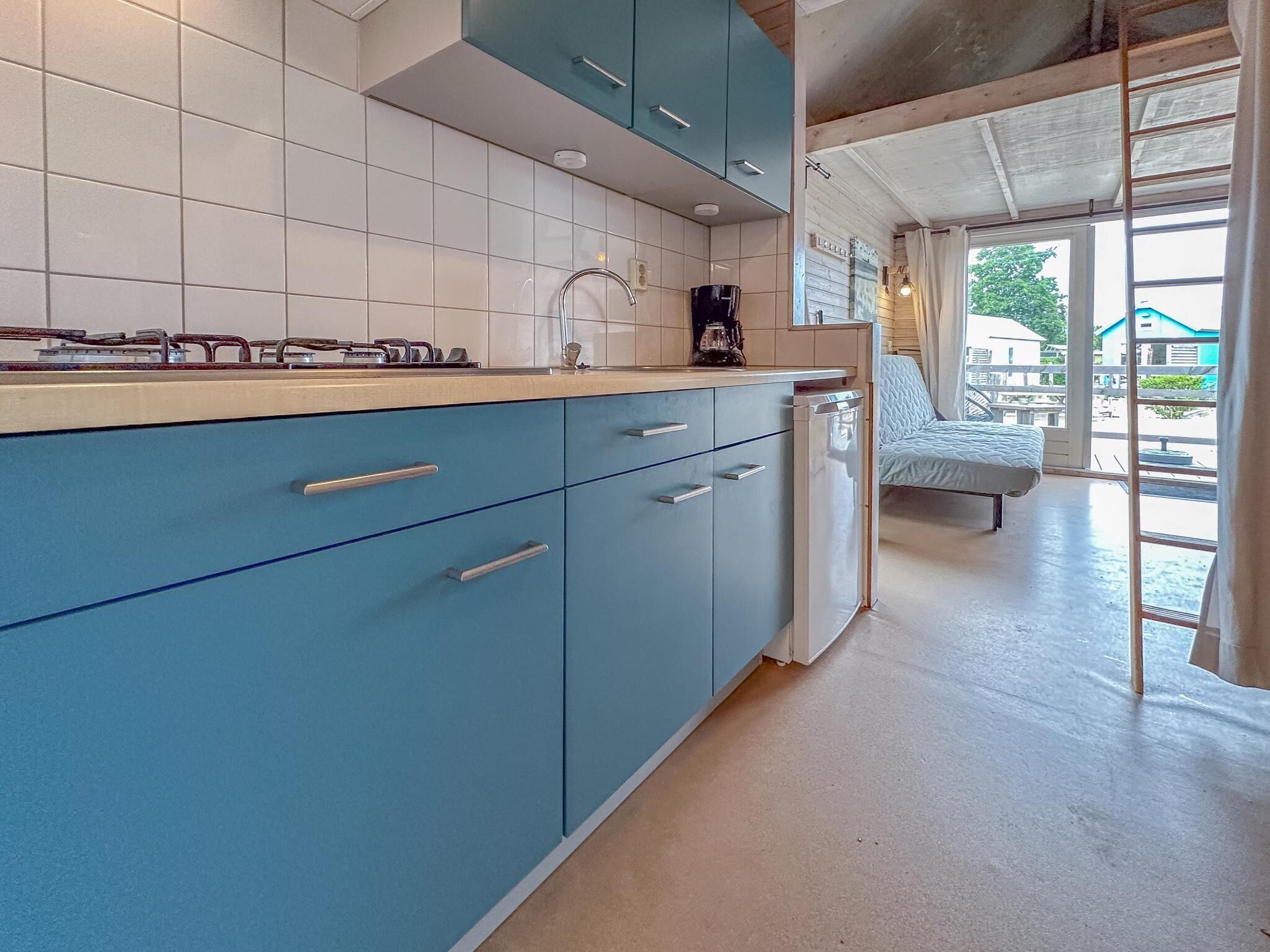 Eine Küche mit blauen Schränken, einem Spülbecken und einer Kaffeemaschine.