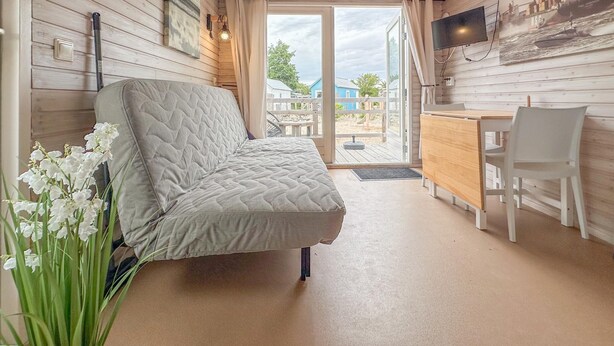 Una habitación acogedora con una cama, un escritorio, una silla y un televisor.