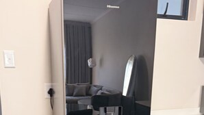 Ett modernt kök med inbyggt kylskåp, mikrovågsugn och kaffemaskin.