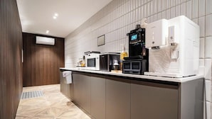 Una cocina moderna equipada con microondas, cafetera y dispensador de agua.