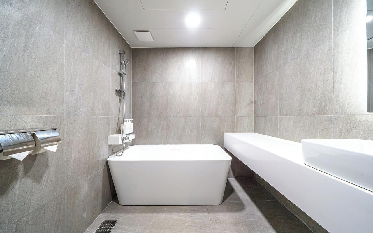 A modern bathroom with a freestanding bathtub, a separate shower area, and a large mirror.