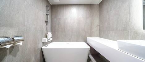 A modern bathroom with a freestanding bathtub, a separate shower area, and a large mirror.