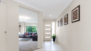Ein Flur mit einer Couch, einem Blumentopf und gerahmten Bildern an der Wand.