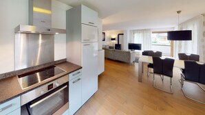 Una cucina moderna con una cappa Bosch, un forno integrato e un'area pranzo con tavolo e sedie.