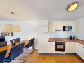 A modern kitchen with white cabinets, a wooden countertop, and a built-in oven. - Walensee House & Apartments, (Unterterzen), by Interhome (Unterterzen)