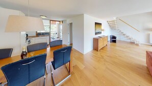 Et moderne interiør med spiseområde, køkken og trappe.