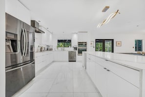 A modern kitchen with white cabinetry, stainless steel appliances, and a central island. - Villa Bellavista, Tropical 5BR Oasis with Private Pool (NE)