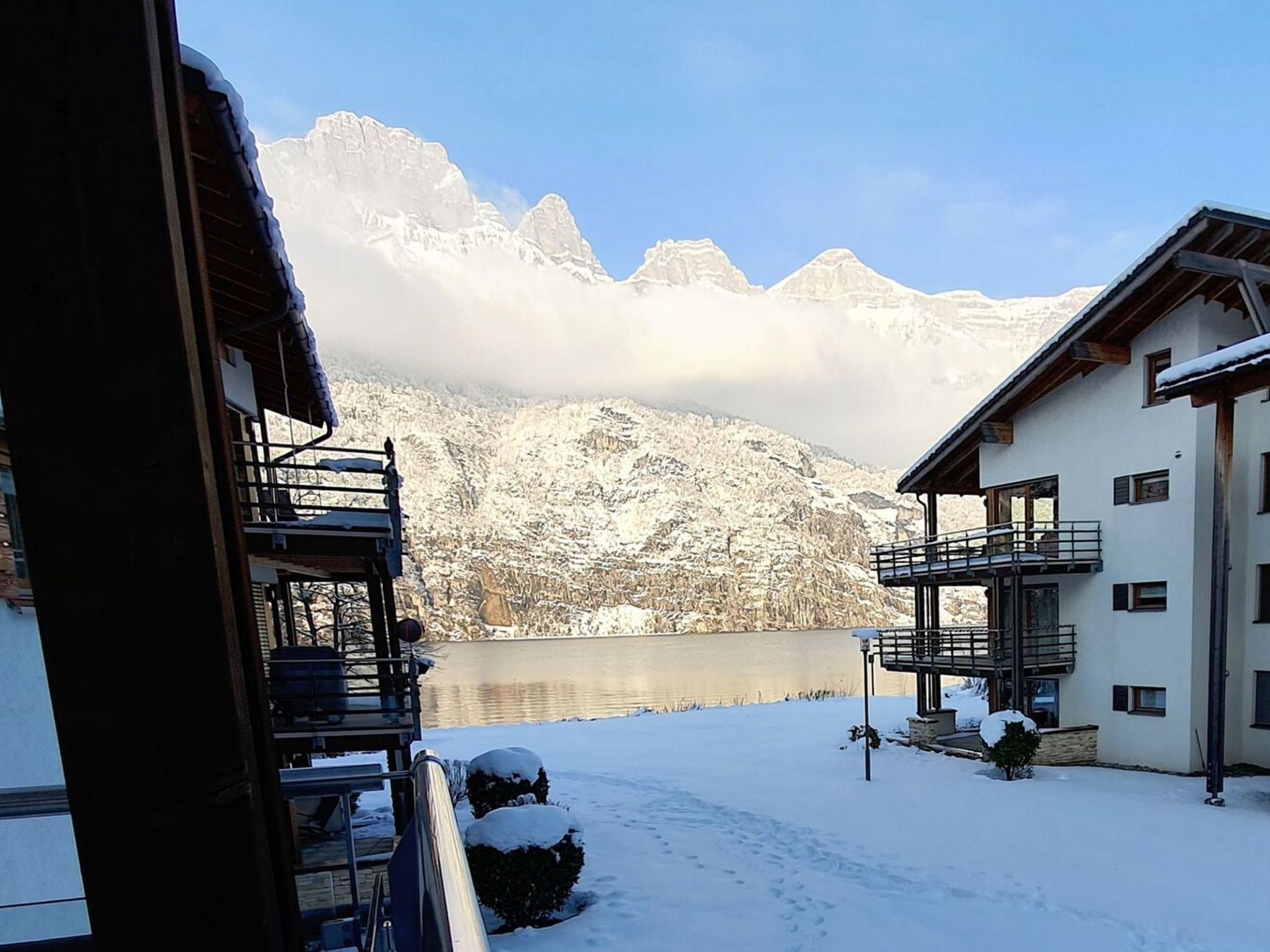 Un espace extérieur enneigé offrant une vue sur les montagnes et un lac.