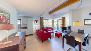 A modern living room with red sofas, a dining table, and a kitchen in the background. - Walensee House & Apartments, (Unterterzen), by Interhome (Unterterzen)