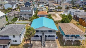 A coastal residential area with houses, a prominent blue-roofed building, and a sandy beach. - Beach Please! · Ocean View 2BR · Cherry Grove (North Myrtle Beach)