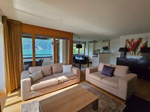 A modern living room with two sofas, a coffee table, and a dining area with a table and chairs.