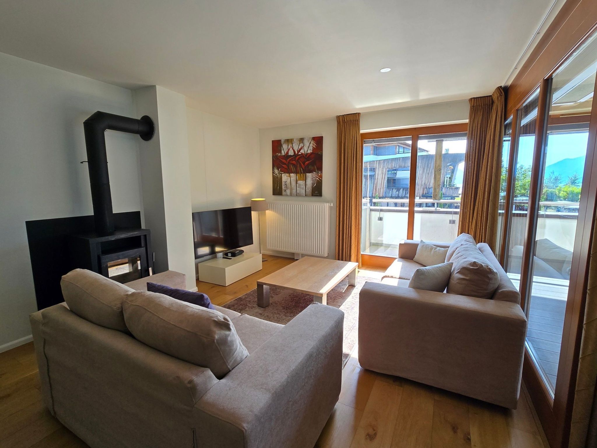 Een moderne woonkamer met een bank, een salontafel, een televisie en een open haard.