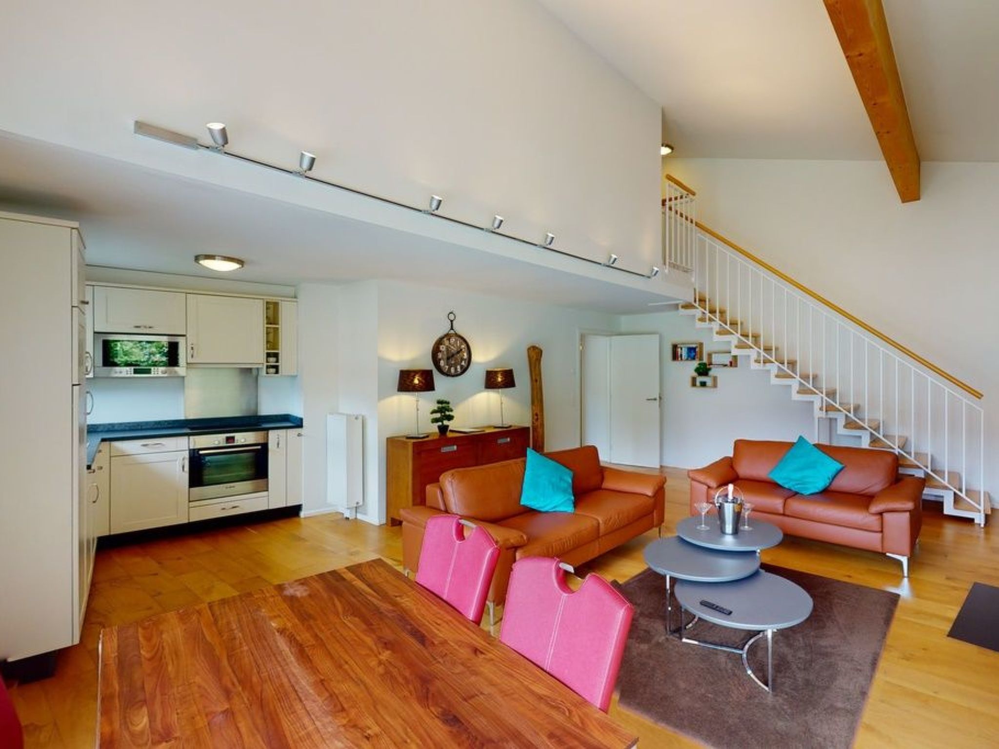 Un apartamento moderno con cocina, sala de estar y escalera.