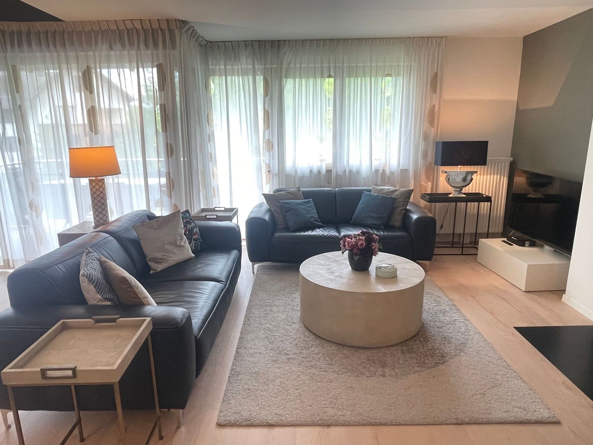 A modern living room with two sofas, a coffee table, and a TV.