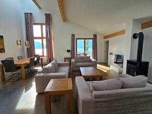Una sala moderna con un conjunto de sofás, una mesa de comedor y una chimenea.