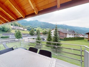 A balcony with a table and chairs, overlooking a residential area with houses and trees. - Walensee House & Apartments, (Unterterzen), by Interhome (Unterterzen)