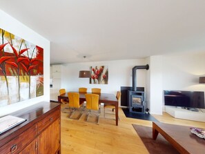 A modern living room with a dining area, a fireplace, and a television. - Walensee House & Apartments, (Unterterzen), by Interhome (Unterterzen)