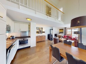 A spacious open-plan living area with a kitchen, dining table, and seating area. - Walensee House & Apartments, (Unterterzen), by Interhome (Unterterzen)