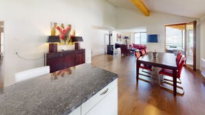 A spacious living area with a dining table, red chairs, a fireplace, and a large window. - Walensee House & Apartments, (Unterterzen), by Interhome (Unterterzen)