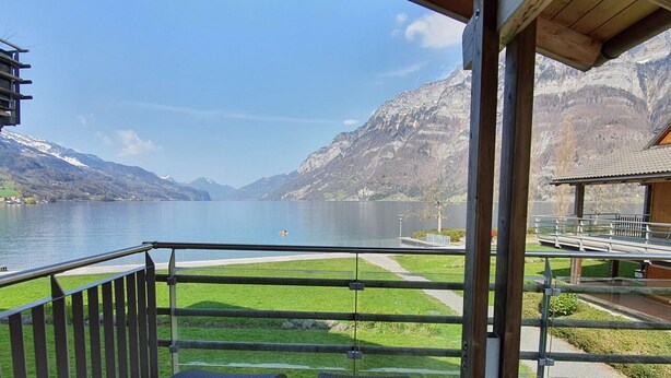A balcony with wicker chairs overlooking a lake and mountains. - Walensee House & Apartments, (Unterterzen), by Interhome (Unterterzen)