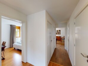 Un corridoio d'albergo con un letto, una scrivania e un'area ristoro.