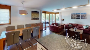 Una cocina moderna con comedor, sofá y vistas al exterior.