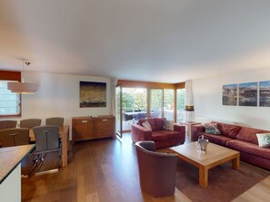 A modern living room with a sofa, coffee table, and dining area. - Walensee House & Apartments, (Unterterzen), by Interhome (Unterterzen)