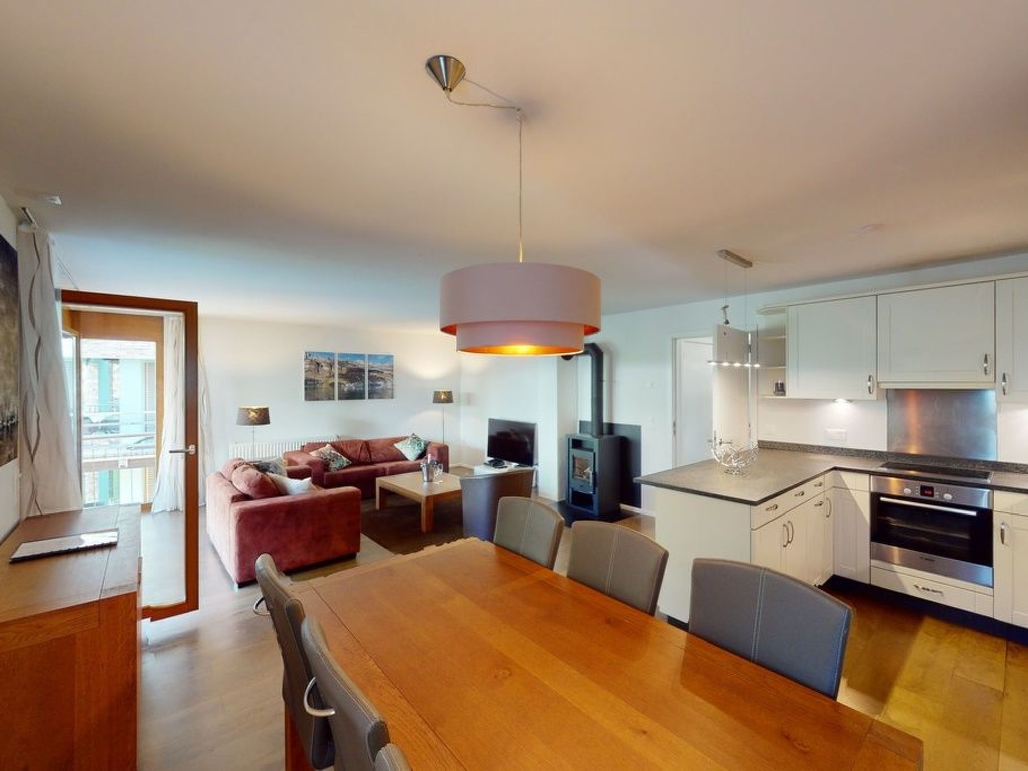 Un ambiente moderno con angolo ristoro, cucina e divano.