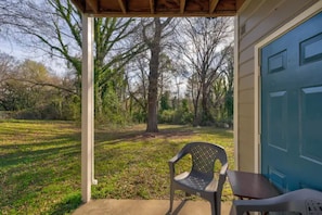 A covered porch with a concrete floor, a blue door, and a chair. - 2-bedroom apartment in tranquil Durham with cool AC breeze (Durham)