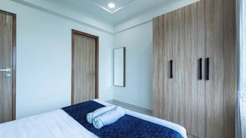 Une chambre d’hôtel avec un lit, une armoire en bois et un miroir.