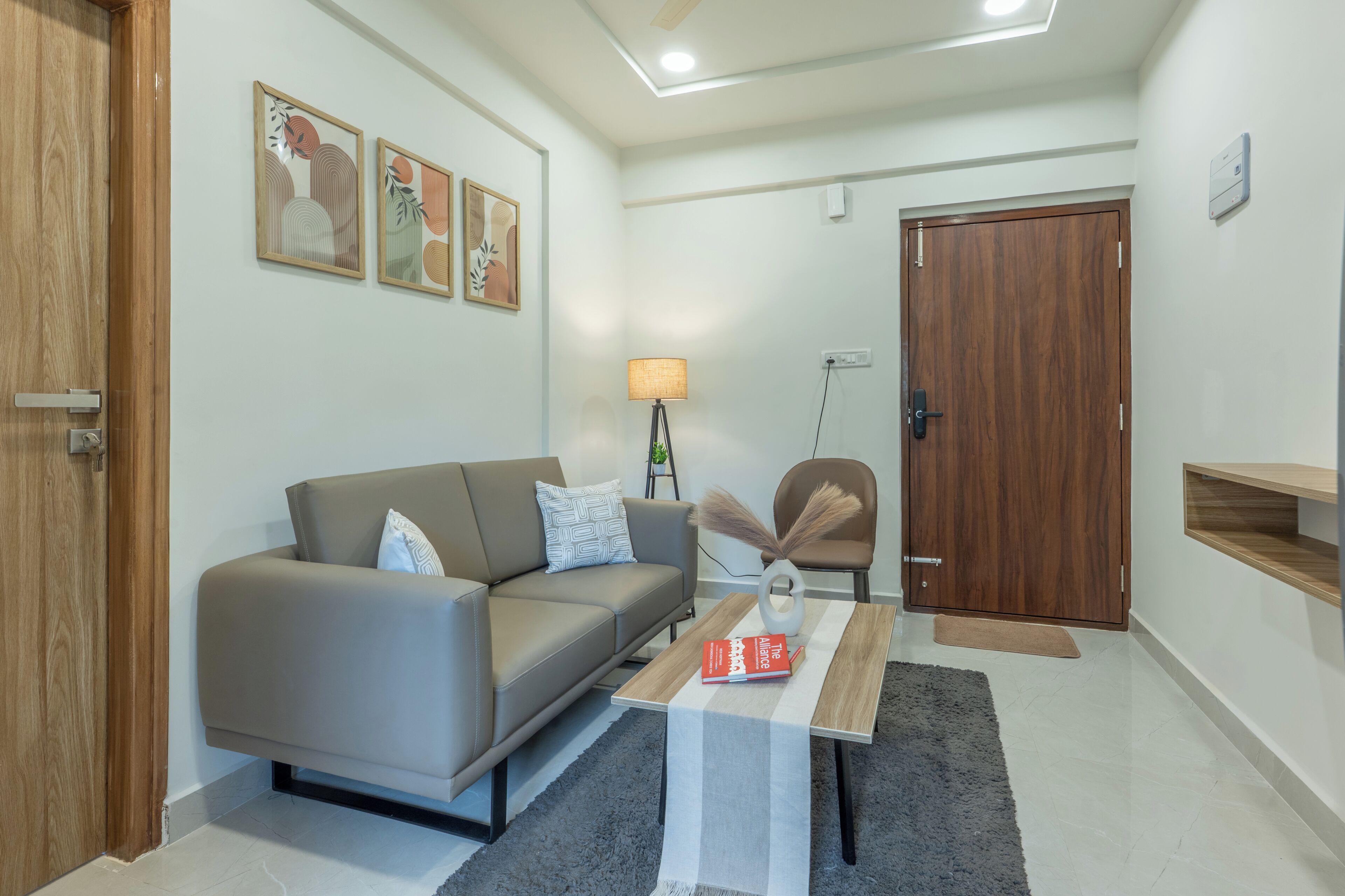 Una sala de estar moderna con un sofá, una mesa de centro, una lámpara y una puerta.