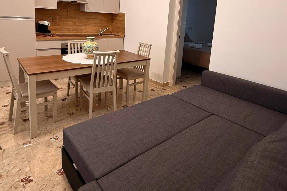 Ein kompakter Wohnbereich mit Essplatz, Küchenzeile und einer Couch.