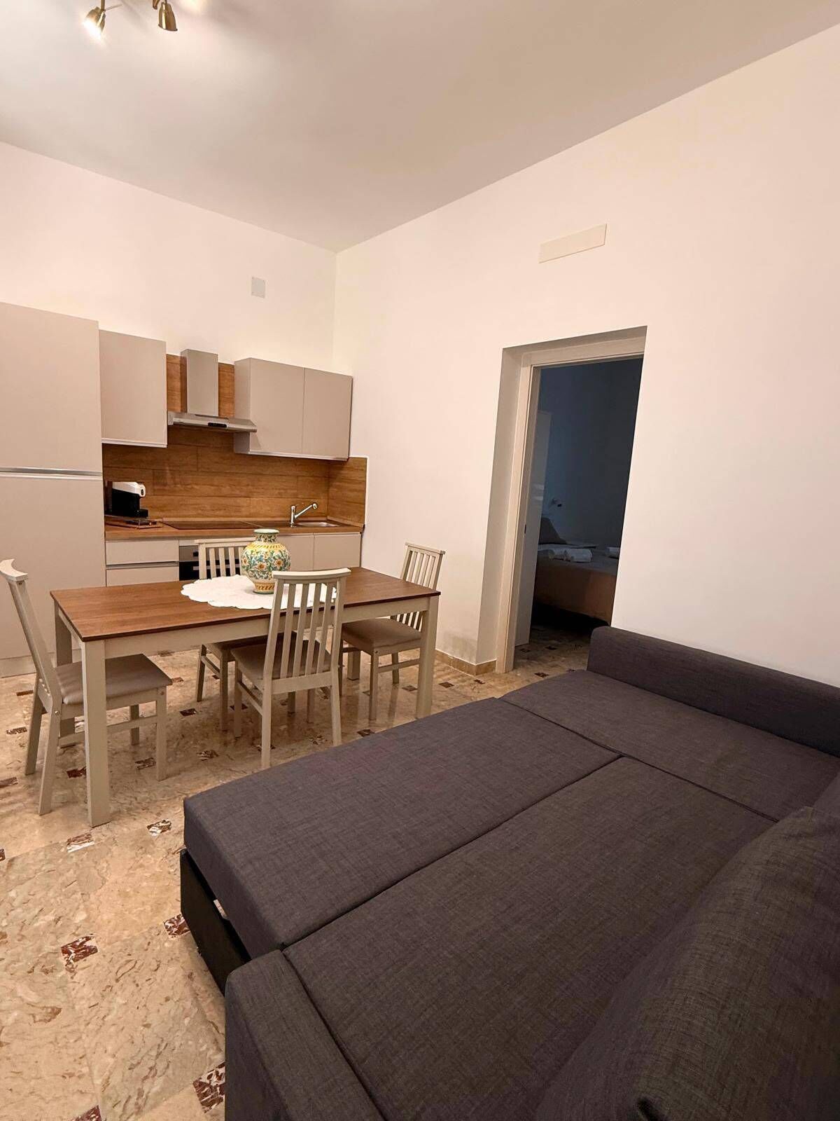 Um espaço compacto com área de jantar, cozinha compacta e sofá.