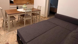 A compact living space with a dining area, kitchenette, and a sofa. - Casa Volqart (Località Rogana I)