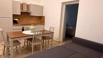 Um espaço compacto com área de jantar, cozinha compacta e sofá.