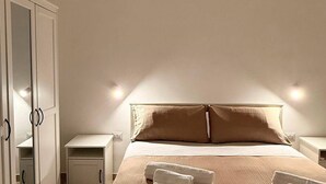 A bedroom with a bed, a nightstand, a wardrobe, and a mirror. - Casa Volqart (Località Rogana I)