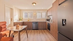 Una cocina moderna con armarios de madera, un refrigerador de acero inoxidable y un lavavajillas.