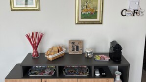 A wooden cabinet with a black top, decorated with various items including a basket of bread, a jar, and a plate of food. - La Casita del Lago is ideal for families or groups. Thank you for choosing us (Lombardia)
