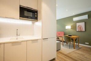 Ett modernt kök med en Bosch-mikrovågsugn, en diskho och en matplats med bord och stolar.