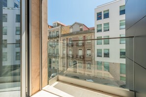 Ein modernes Gebäude mit einem Glasbalkon mit Blick auf ältere Bauten.
