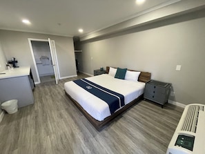 A hotel room with a bed, bedside table, and a small desk area. - SGV+Disney+Rose Bowl•King Studio near DTLA (Alhambra)