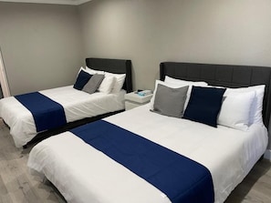 Two beds with white and blue bedding, a nightstand, and a grey headboard. - SGV+Disney+Rose Bowl • Quadruple Rm near DTLA (Alhambra)