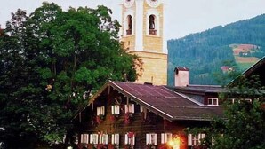 A church with a bell tower and a building with a sloped roof in front. - Markterwirt (Altenmarkt im Pongau)